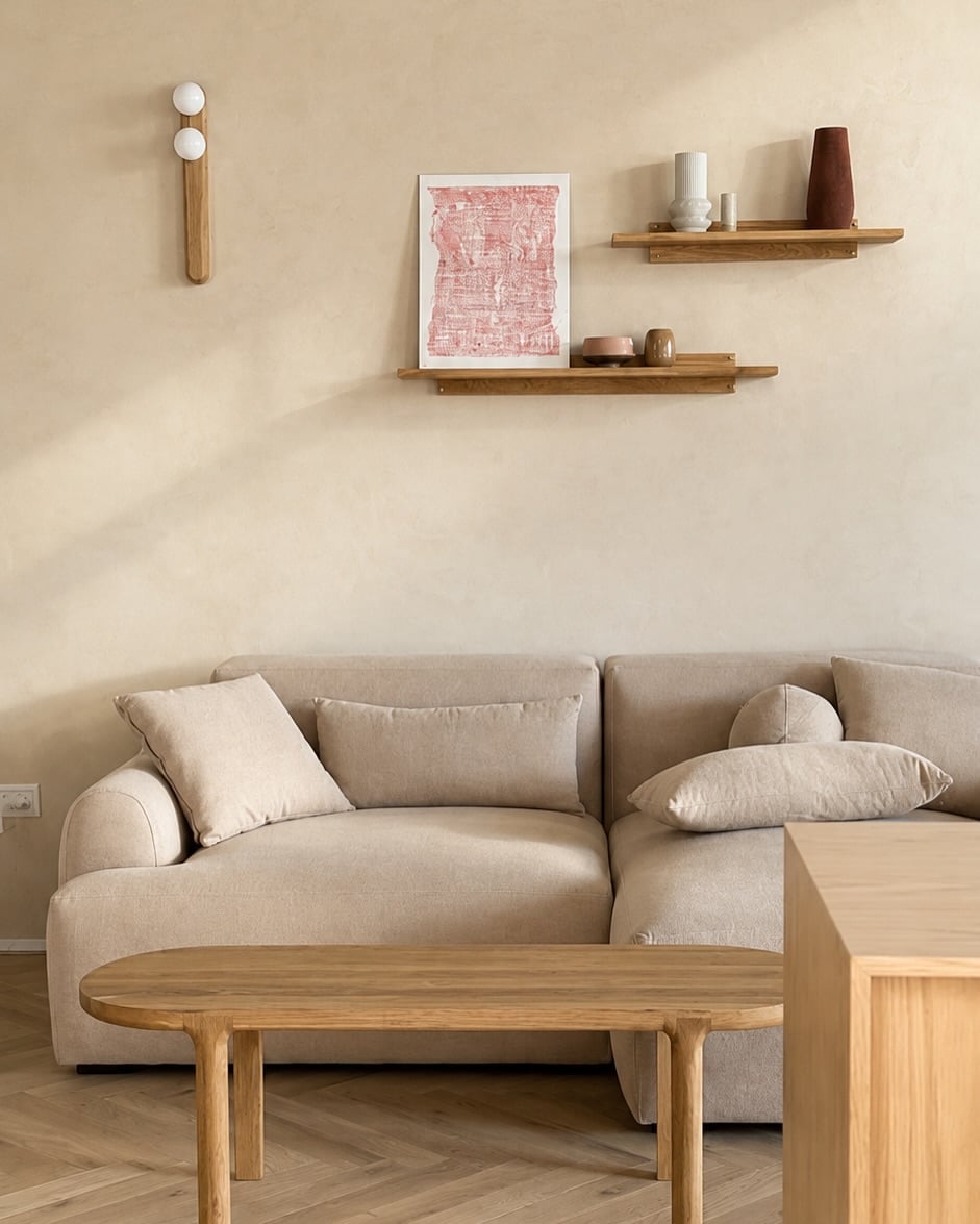 Vista del sofá claro con mesa de madera y estantes decorativos