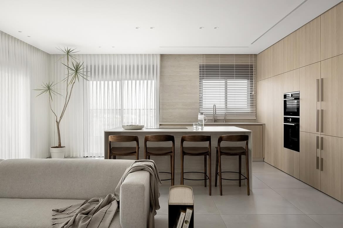 Vista de la cocina con isla y banquetas integrada al living