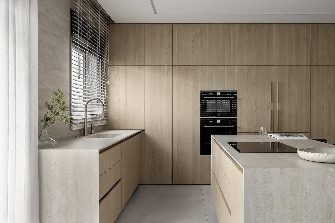 Vista de la cocina con mesadas claras y muebles de madera