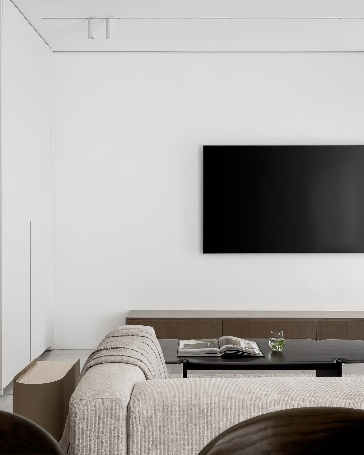 Vista del living con sofá claro, mesa baja y televisión