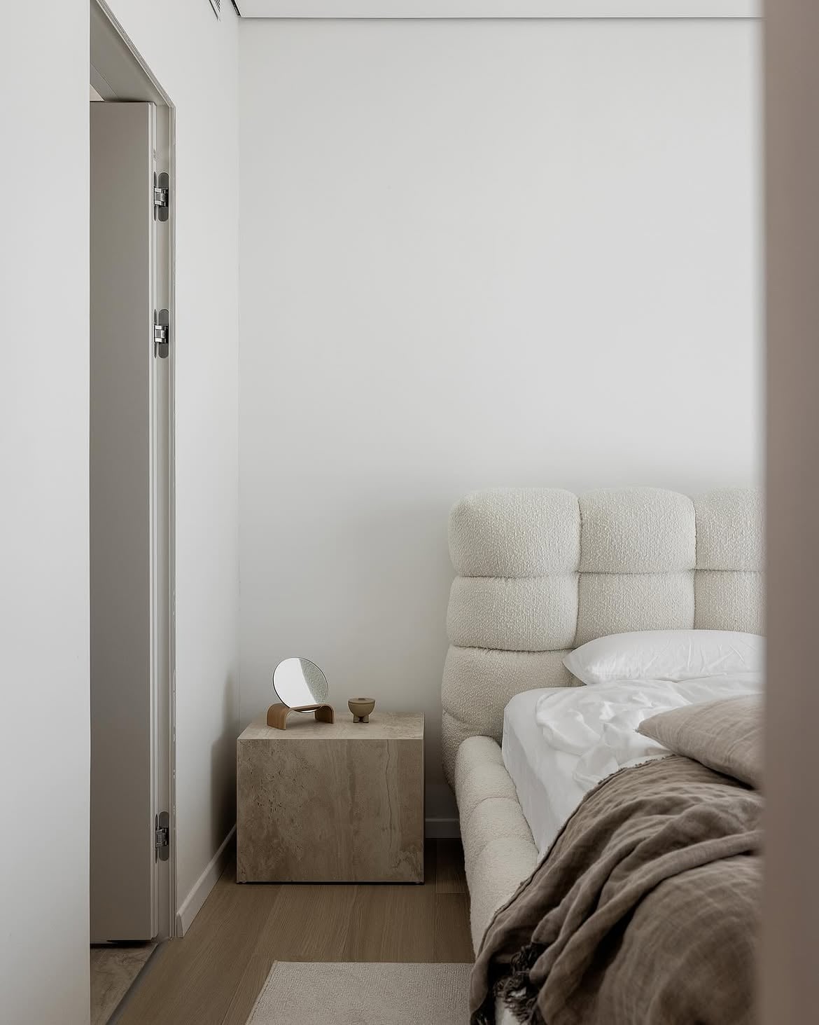 Vista lateral de la cama y la mesa de luz junto al acceso