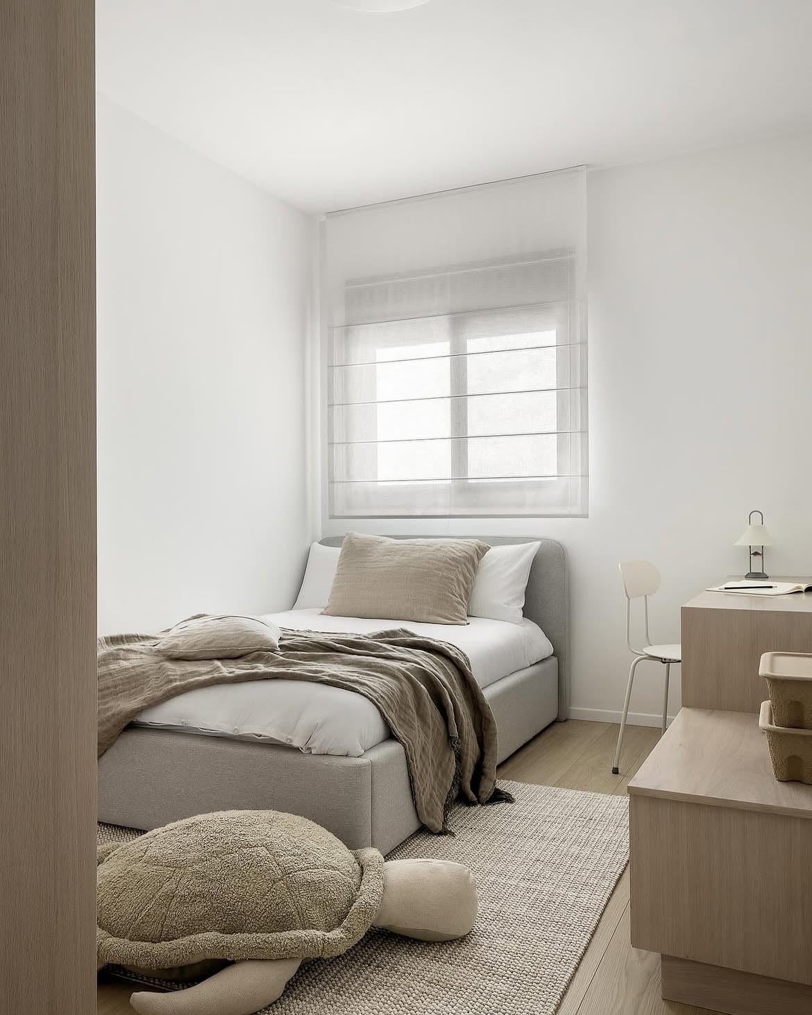 Vista del dormitorio individual con cama, escritorio y tortuga de peluche