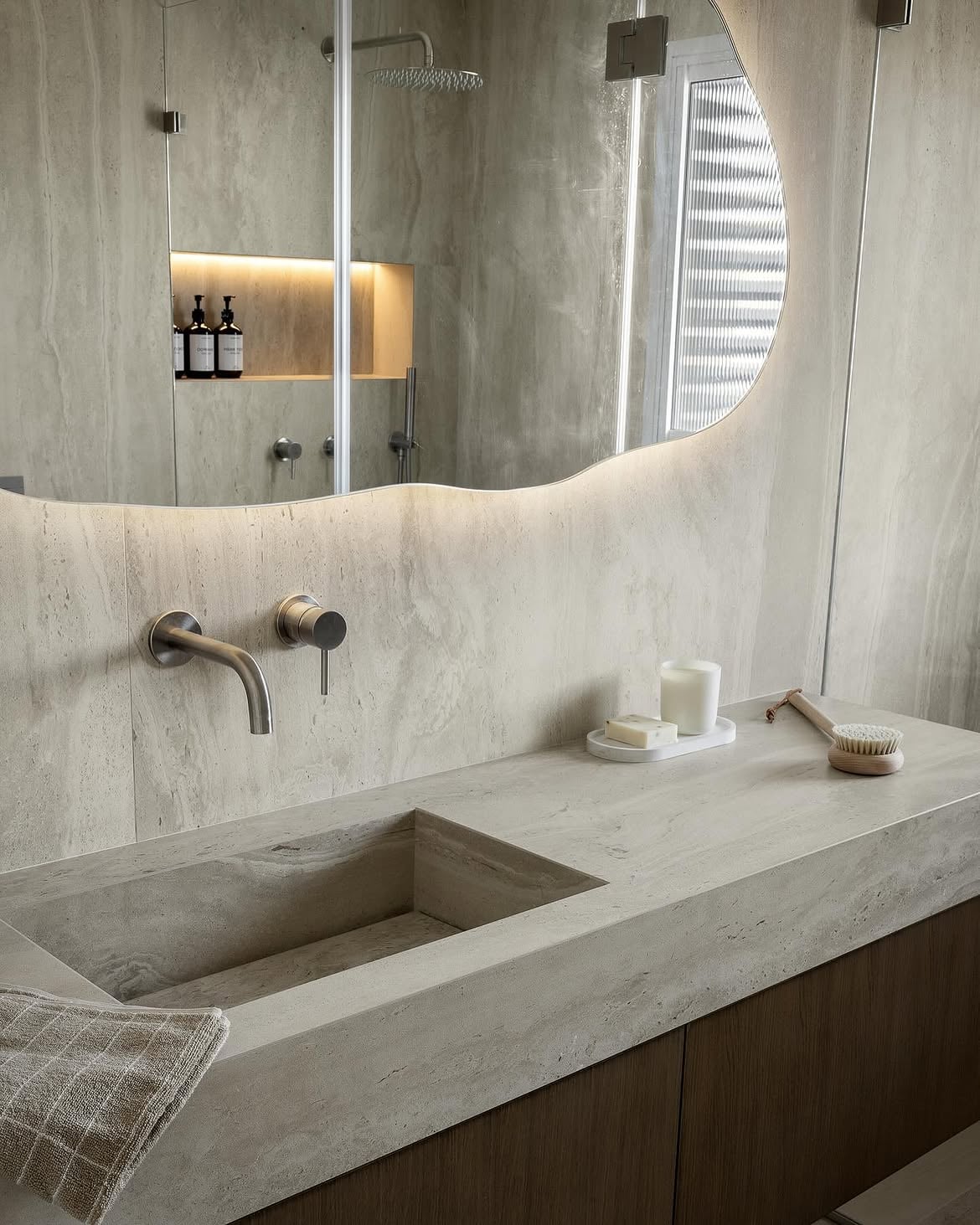 Detalle del lavamanos, la grifería y el espejo del baño