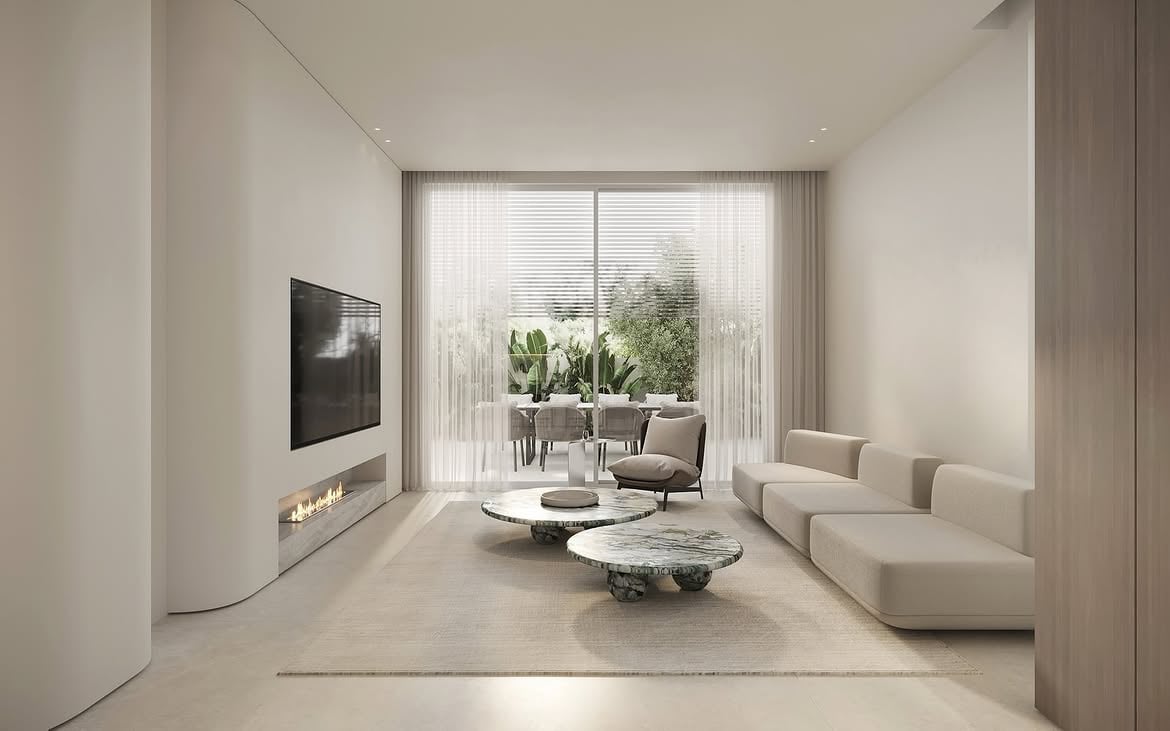 Vista del living con sofá claro y ventanal hacia el comedor exterior